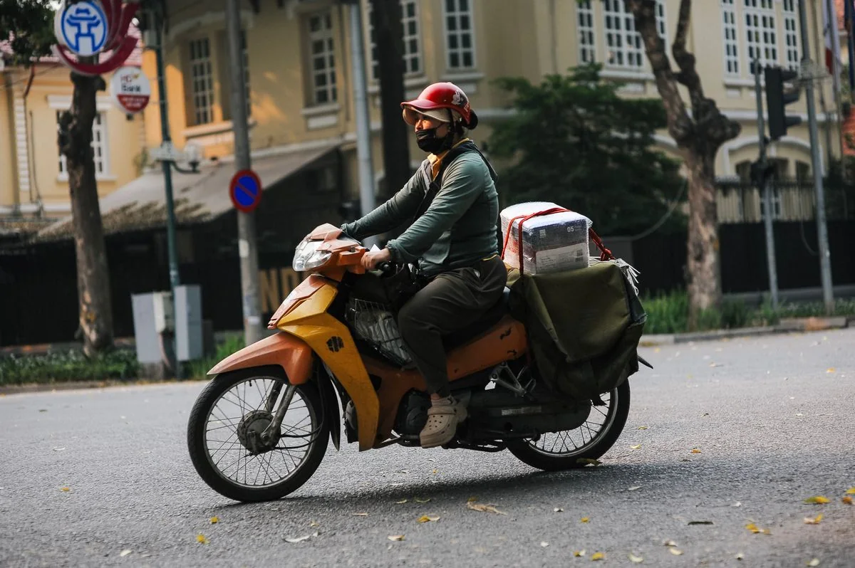 Şehir içinde paket taşıyan gerçek kurye motosikleti